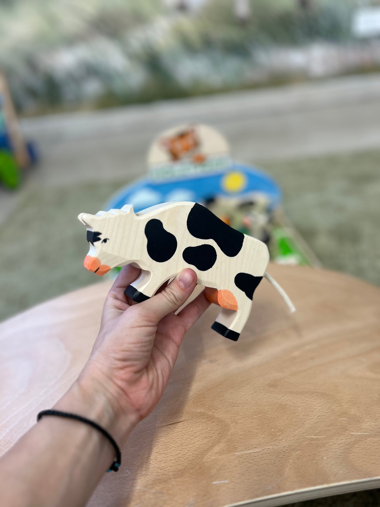 Mucca nera che bruca, in legno, Holztiger